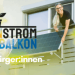 Frau steht am Balkon vor ihrem Balkonsolarmodul.