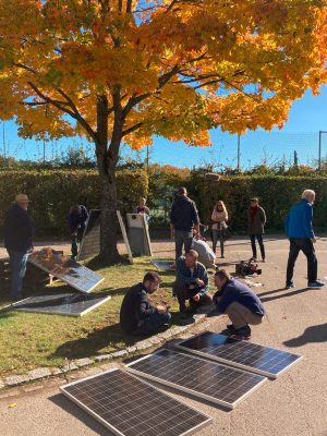 Balkonsolarworkshop in Freiburg draußen und mit Balkonsolarmodulen, die gerade getestet werden
