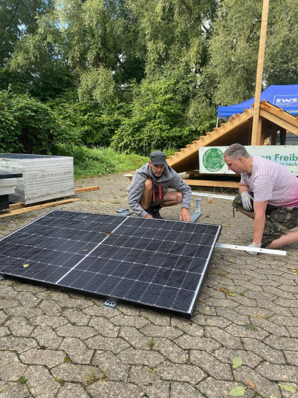 Ein Workshop-Leiter erklärt einem BalkonScout etwas an einem Solarmodul.
